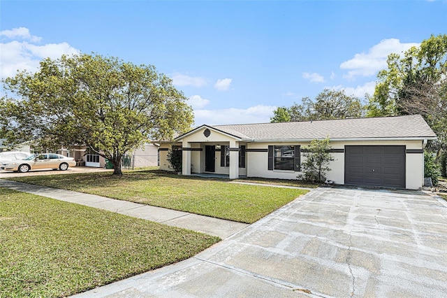 view of front of house with a front yard, concrete driveway, a garage, and stucco siding