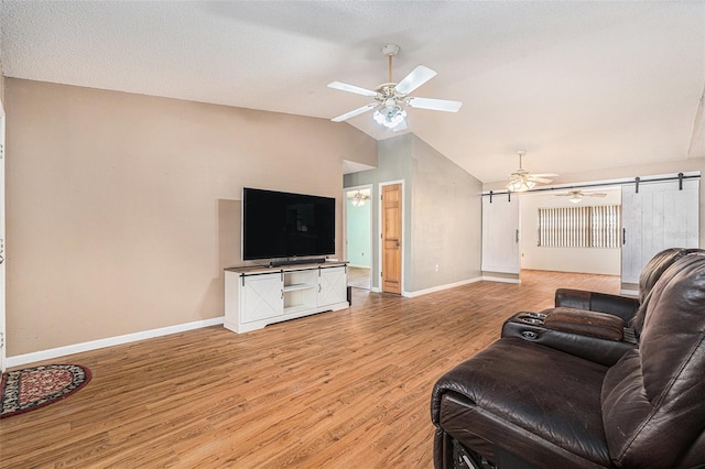 living room featuring vaulted ceiling, a ceiling fan, baseboards, and light wood finished floors