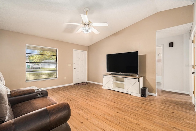 living area featuring baseboards, light wood-style flooring, a ceiling fan, and lofted ceiling