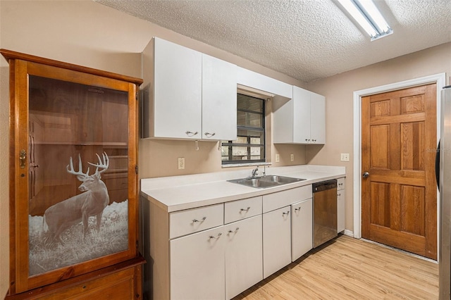 kitchen featuring light wood-style flooring, a sink, light countertops, white cabinets, and stainless steel dishwasher