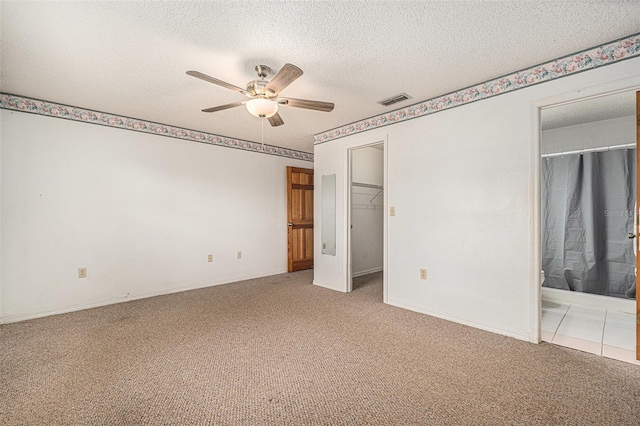 spare room with visible vents, a ceiling fan, a textured ceiling, carpet flooring, and baseboards