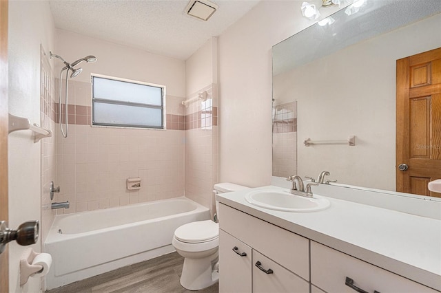 bathroom with vanity, wood finished floors, bathtub / shower combination, a textured ceiling, and toilet