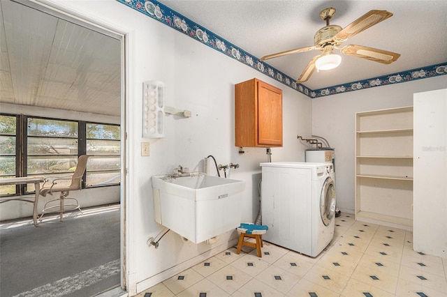 washroom with a sink, water heater, cabinet space, washer / dryer, and ceiling fan