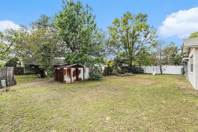 view of yard with a storage unit, a fenced backyard, and an outdoor structure