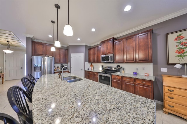 kitchen with ornamental molding, a sink, stainless steel appliances, light tile patterned floors, and a large island with sink