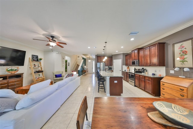 kitchen featuring light tile patterned floors, open floor plan, stainless steel appliances, and a kitchen bar