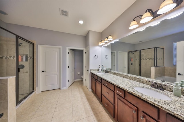 bathroom with a sink, toilet, a shower stall, and tile patterned floors