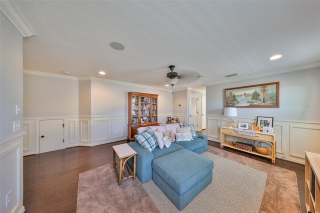 living room featuring dark wood-style floors, visible vents, crown molding, and a ceiling fan