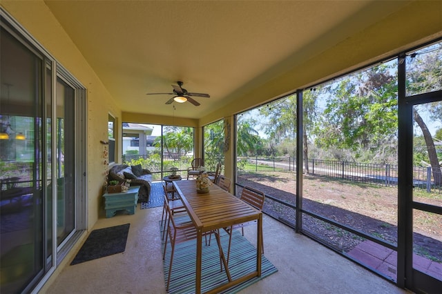 unfurnished sunroom with ceiling fan