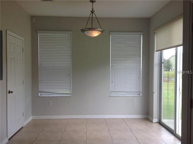 spare room with light tile patterned floors and baseboards