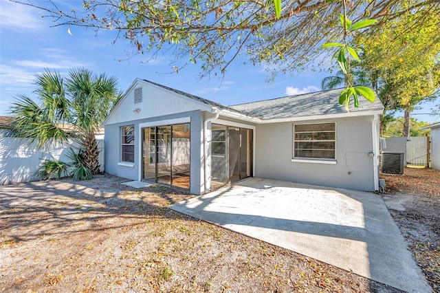 back of house featuring concrete block siding, a patio, a gate, fence, and roof with shingles