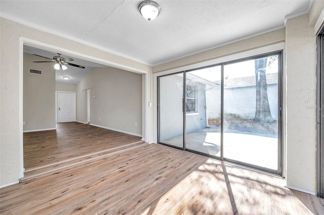 unfurnished room featuring visible vents, ceiling fan, baseboards, wood finished floors, and a textured ceiling