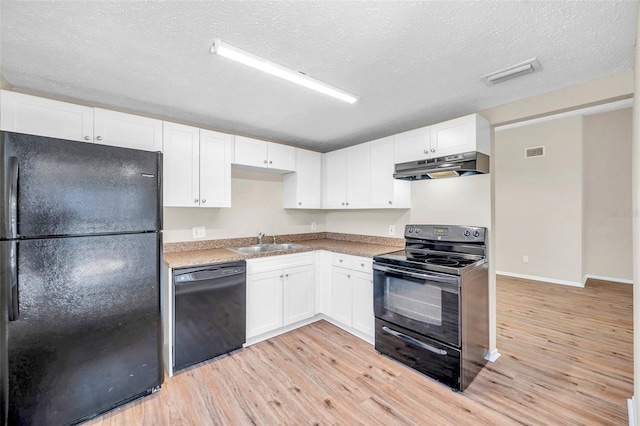 kitchen with under cabinet range hood, visible vents, black appliances, and a sink