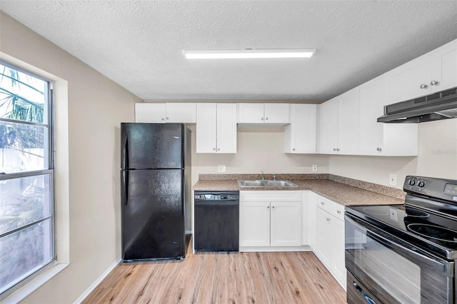 kitchen with white cabinetry, black appliances, under cabinet range hood, and a sink