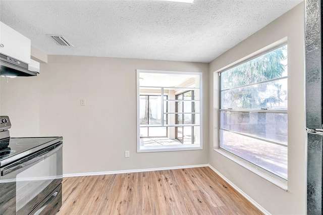 kitchen with visible vents, baseboards, under cabinet range hood, light wood-type flooring, and black electric range