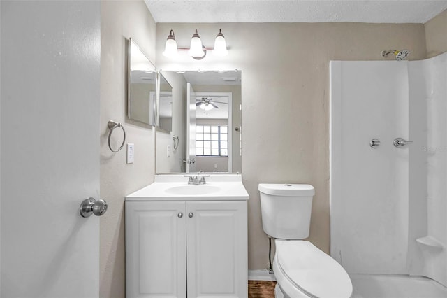 full bathroom with walk in shower, ceiling fan, toilet, vanity, and a textured ceiling