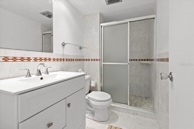bathroom with toilet, tile walls, a stall shower, and vanity