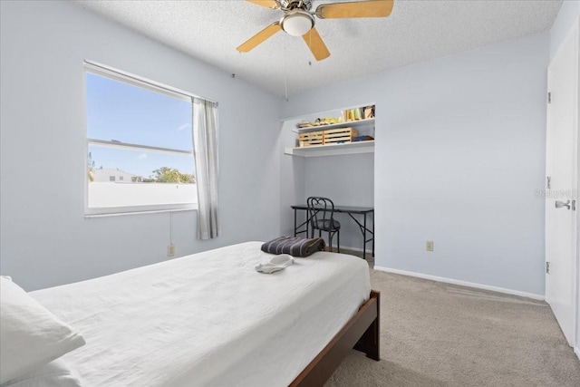 bedroom featuring baseboards, a textured ceiling, ceiling fan, and carpet flooring