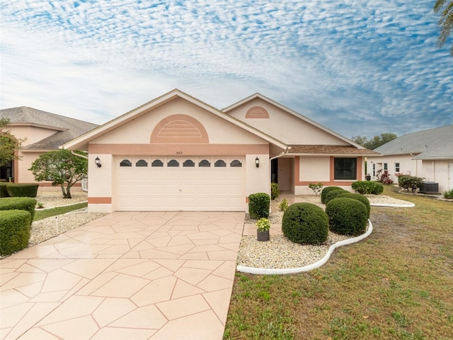 single story home with central AC unit, stucco siding, driveway, and a garage