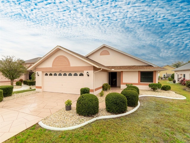 ranch-style home featuring a front yard, a garage, driveway, and stucco siding