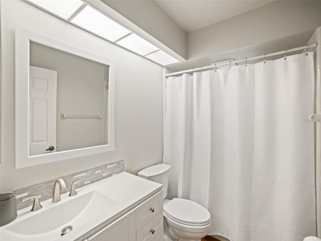 bathroom featuring a shower with curtain, toilet, and vanity