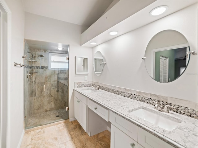 full bath featuring a sink, double vanity, and a shower stall