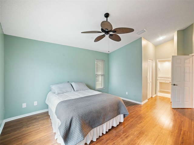 bedroom featuring visible vents, wood finished floors, baseboards, ceiling fan, and vaulted ceiling