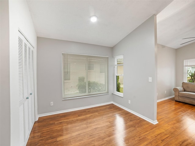 interior space featuring baseboards, lofted ceiling, and wood finished floors