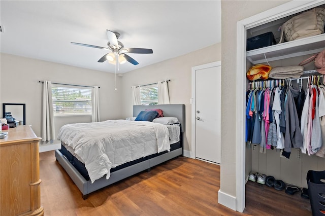 bedroom with a closet, baseboards, wood finished floors, and a ceiling fan