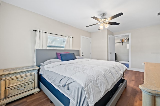 bedroom with dark wood-style floors, visible vents, and ceiling fan