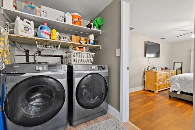 laundry area featuring wood finished floors, visible vents, baseboards, ceiling fan, and independent washer and dryer