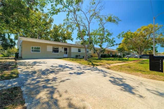 ranch-style house featuring a front yard and driveway