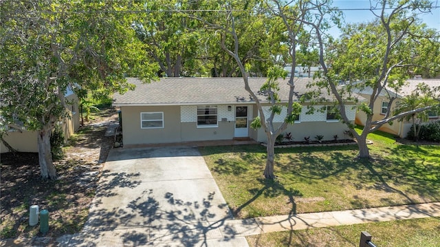 single story home featuring driveway, stucco siding, a shingled roof, a front lawn, and brick siding