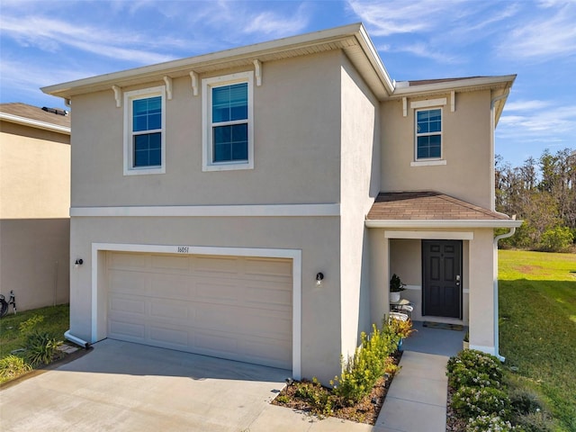 view of front facade with concrete driveway, an attached garage, and stucco siding