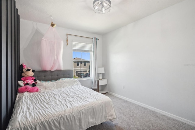 bedroom featuring carpet and baseboards