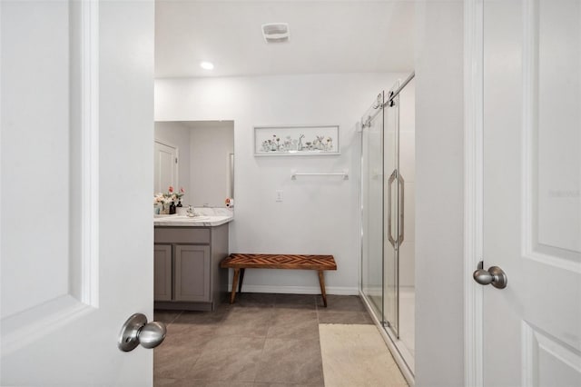 full bath with vanity, baseboards, and a stall shower