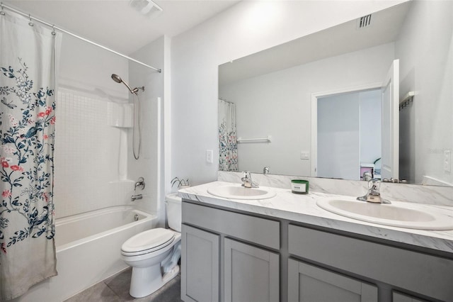 bathroom with double vanity, toilet, visible vents, and a sink