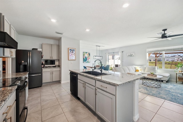 kitchen with light tile patterned floors, open floor plan, black appliances, and a sink