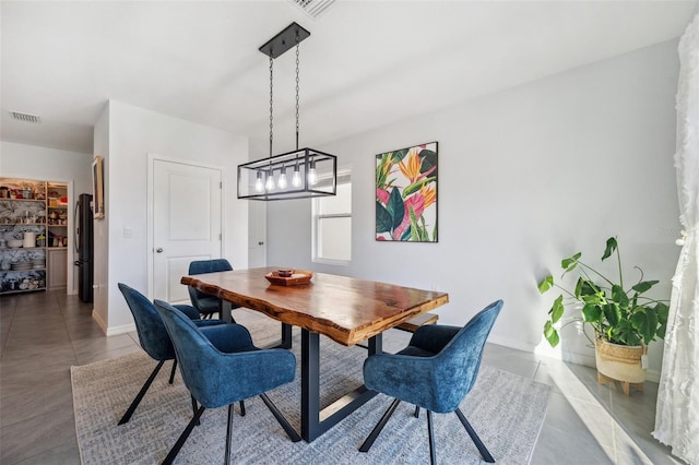 tiled dining space with baseboards and visible vents