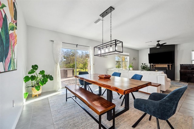 tiled dining room featuring baseboards, visible vents, and ceiling fan