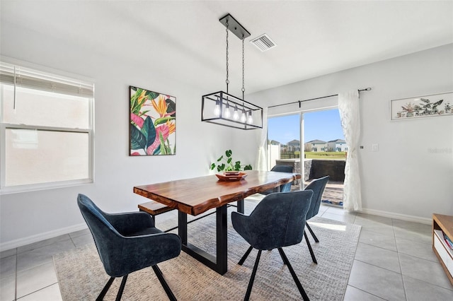 dining area featuring light tile patterned floors, baseboards, and visible vents