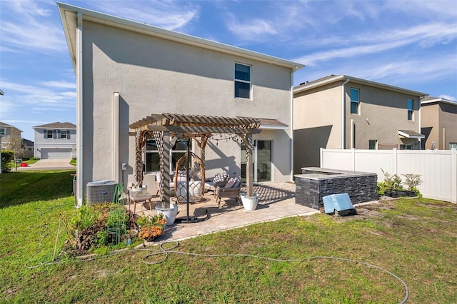 rear view of house featuring fence, stucco siding, a yard, a patio area, and a pergola