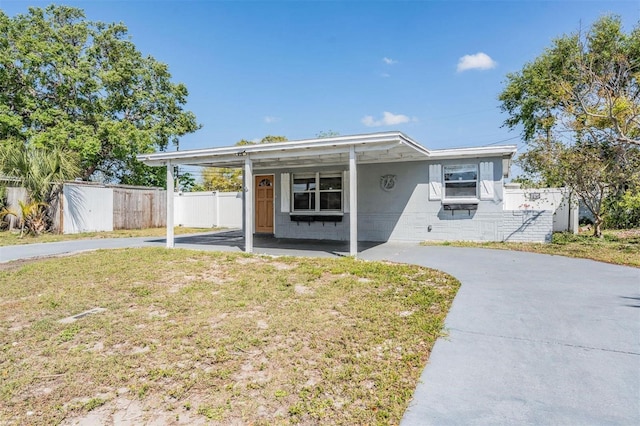 10309 108th Ave, Largo, FL 33773 - view of front of home featuring an attached carport, concrete driveway, fence, and concrete block siding