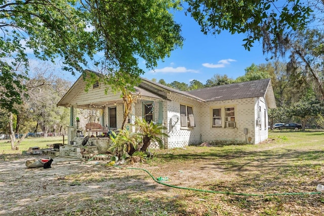 bungalow with cooling unit and a front lawn