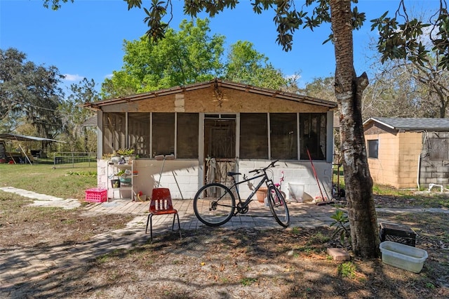 back of property with an outbuilding and a sunroom