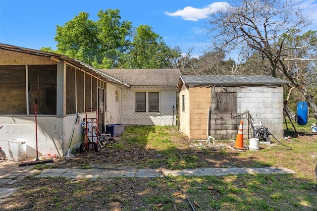 exterior space featuring roof with shingles and a sunroom