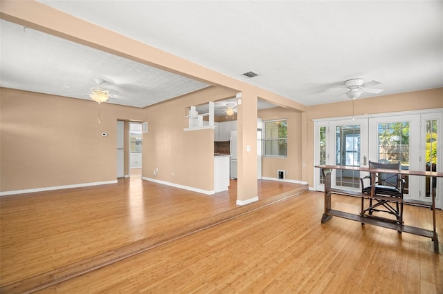 interior space with light wood-type flooring, baseboards, visible vents, and ceiling fan