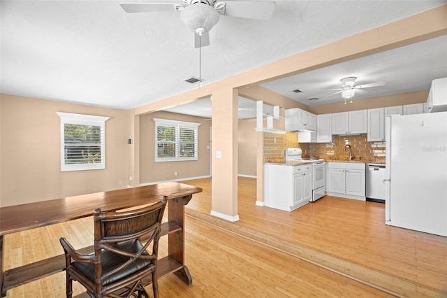 kitchen featuring visible vents, a ceiling fan, a sink, tasteful backsplash, and white appliances