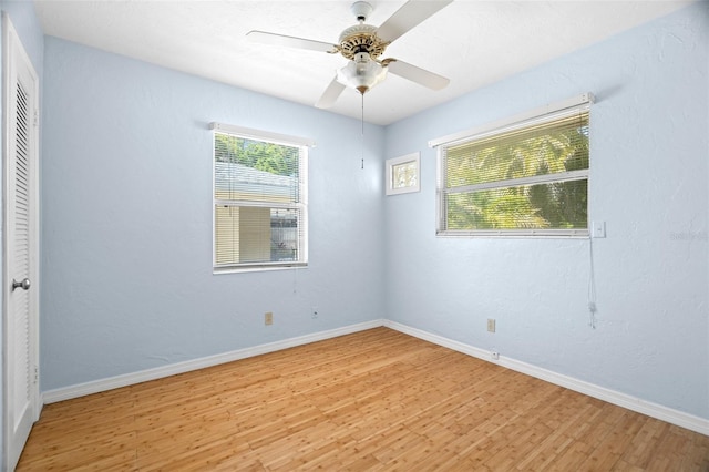 unfurnished room featuring baseboards, light wood-type flooring, and ceiling fan