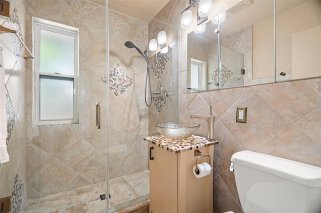 full bathroom with vanity, tile walls, toilet, and a stall shower